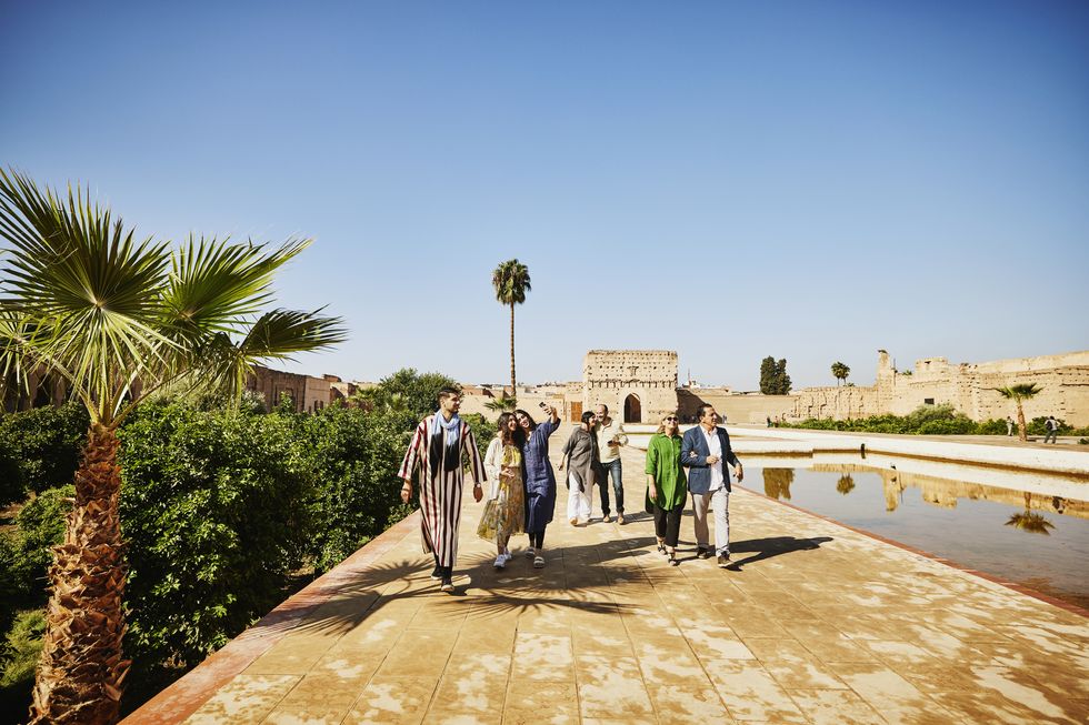 wide shot of tour guide leading tourist on tour of el badi palace
