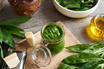 wild garlic or ramson pesto in a glass jar, with parmesan cheese