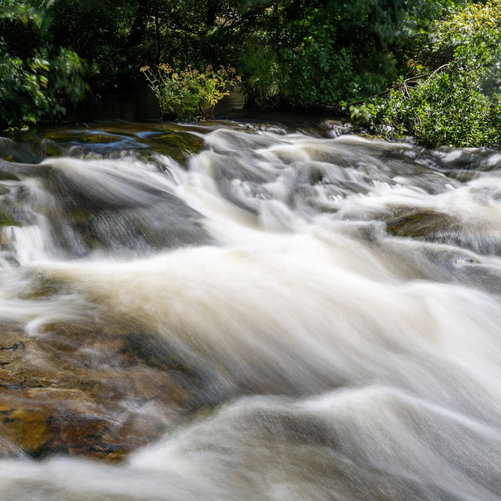 long exposure of a waterfall on the east lyn river flowing through the doone valley in exmoor national park