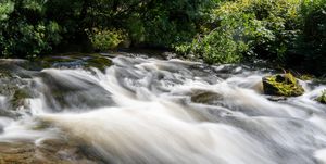 long exposure of a waterfall on the east lyn river flowing through the doone valley in exmoor national park