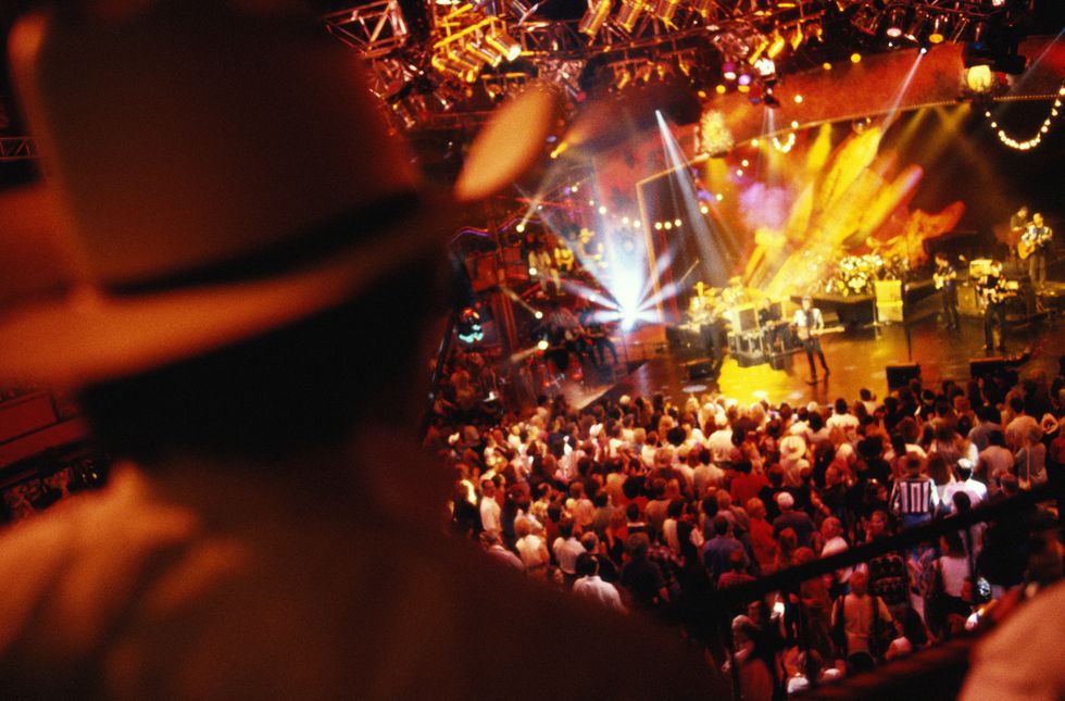 looking down from the upper level of the wildhorse saloon to the crowded dance floor and a band playing on stage below