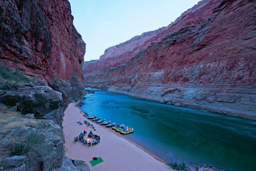 In de avondschemer rusten reizigers uit rond een kampvuur in de Marble Canyon