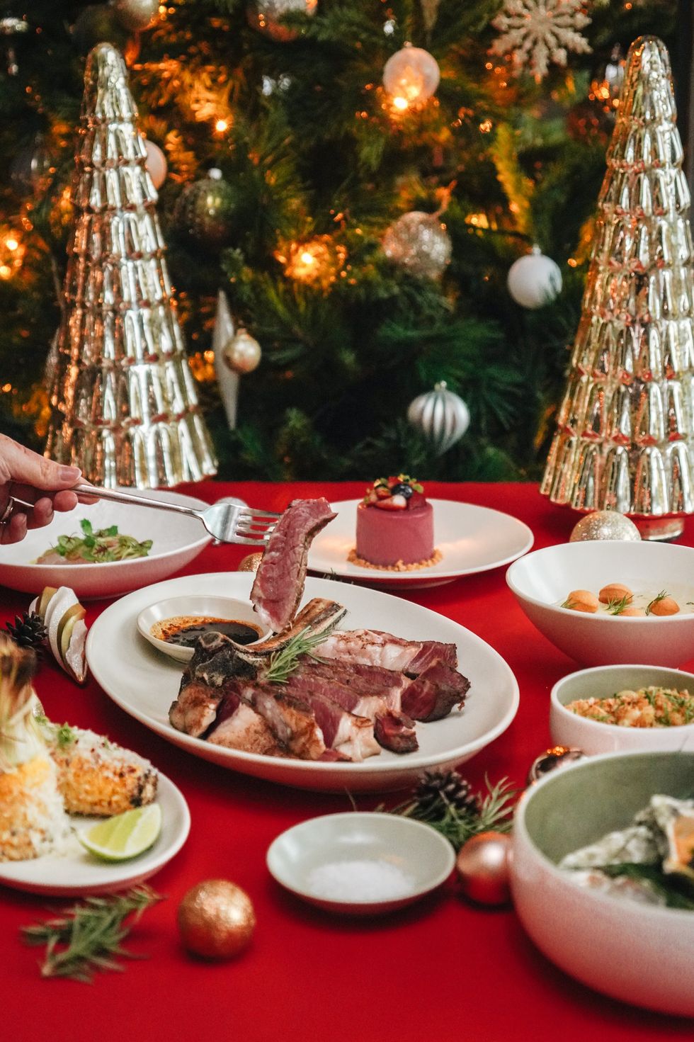 a table with plates of food and a christmas tree