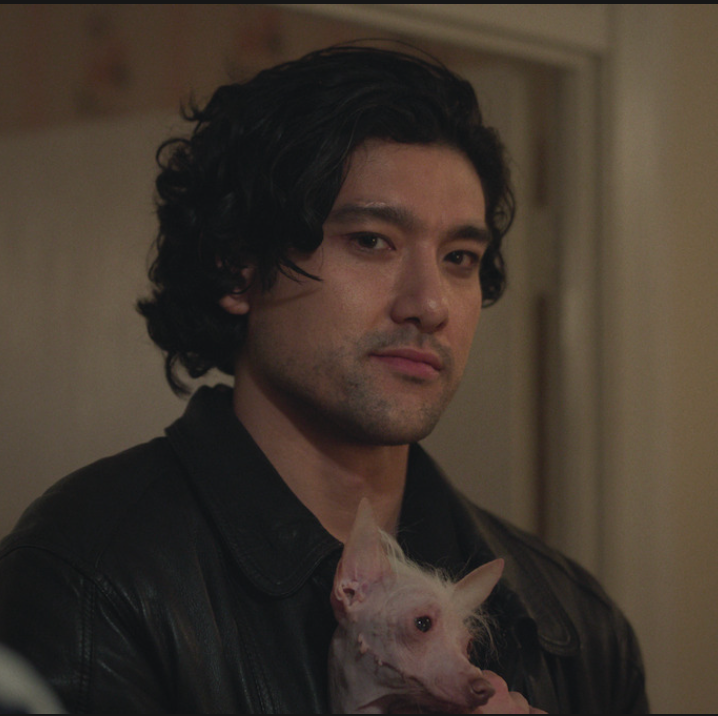 a person holding a small hairless dog indoors