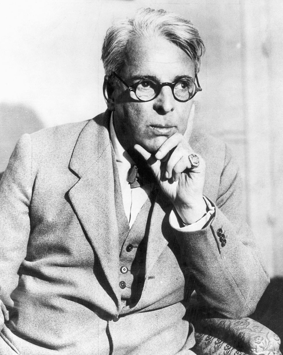poet william butler yeats sitting in chair and resting his head with his left hand in a thinking posture