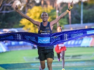runner celebrating a victory at a marathon finish line
