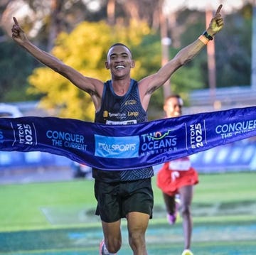 runner celebrating a victory at a marathon finish line runner celebrating a victory at a marathon finish line