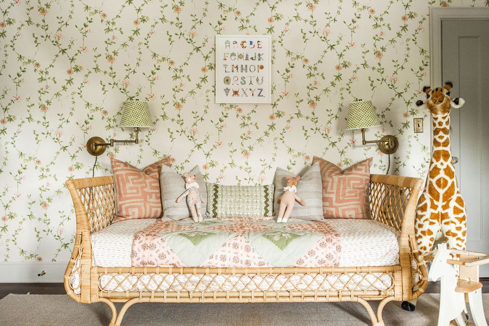 nursery, floral wallpaper, wicker day bed, giraffe stuffed toy