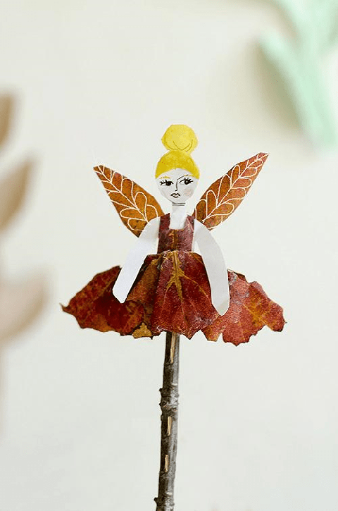 a fairy puppet is made from leaves on a stick