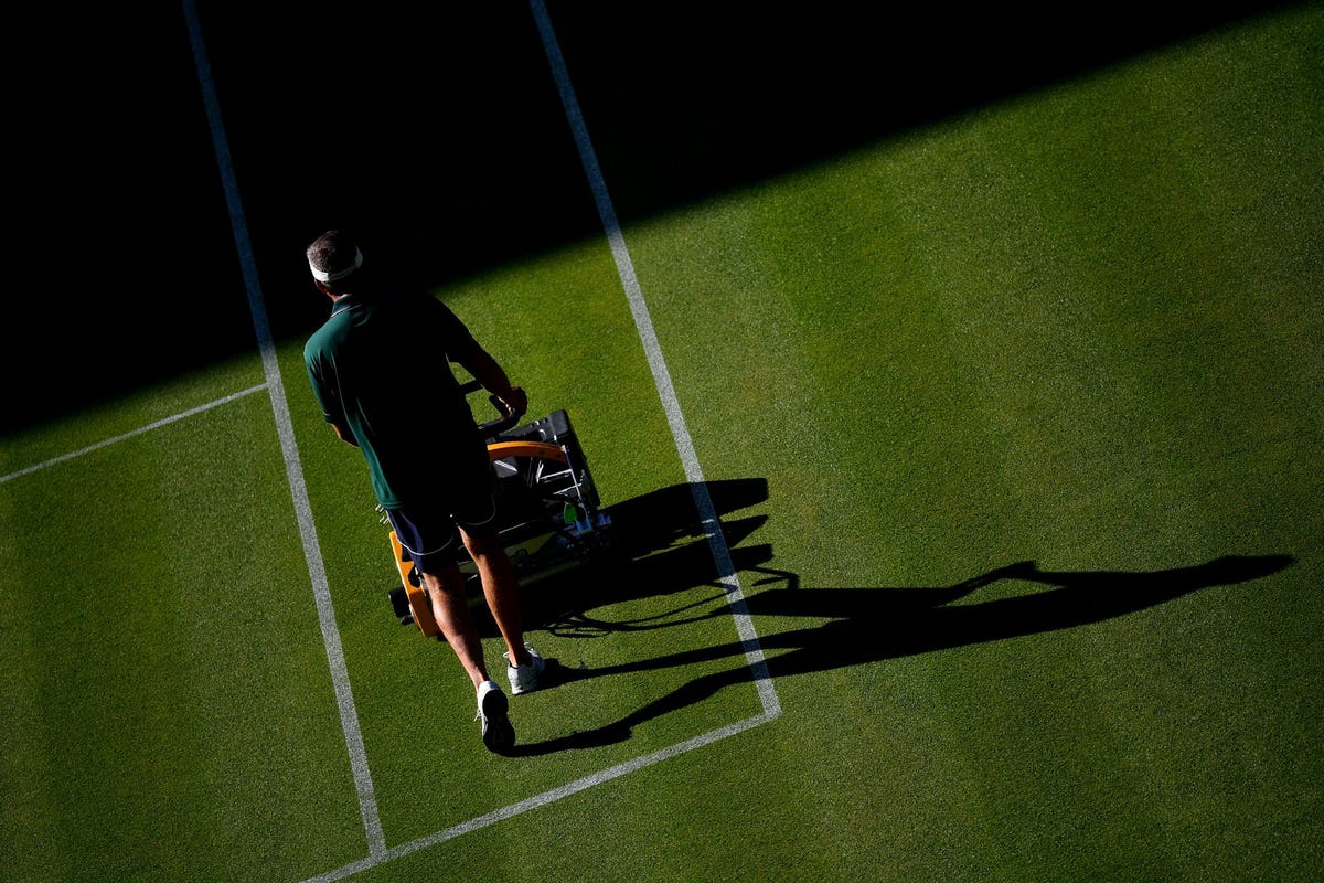 Op de eerste dag van het Wimbledontoernooi van dit jaar maait een terreinverzorger het gras op het Centre Court van de All England Tennis Club