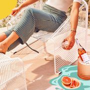 woman in summer clothes outside drinking winc summer water societe rose
