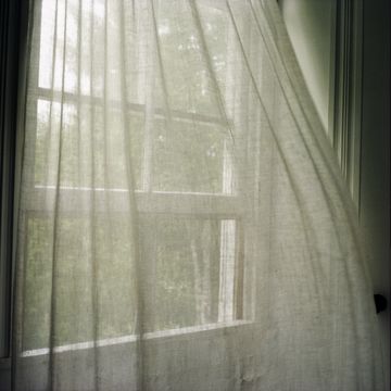 window curtains blown by breeze