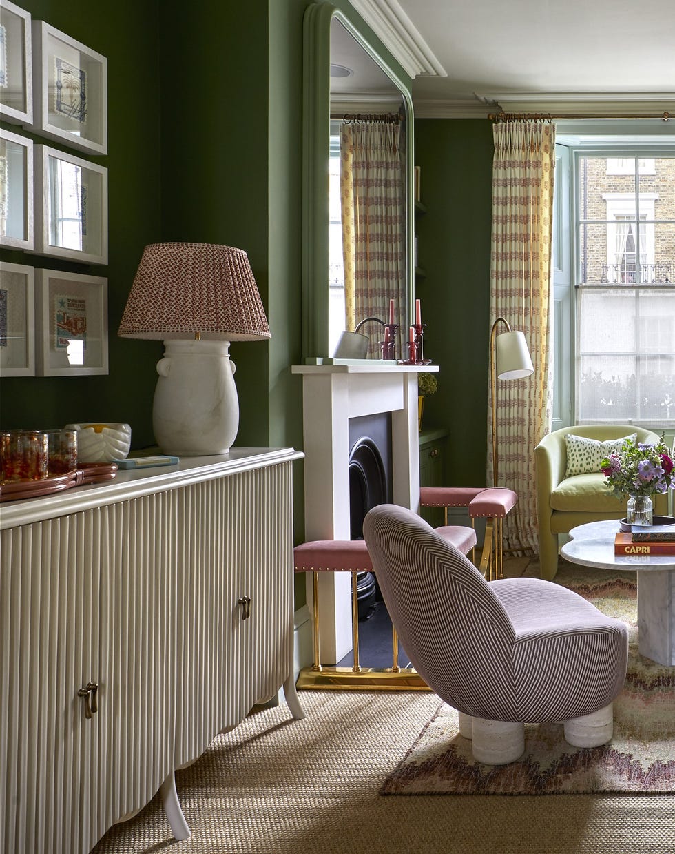 green living room with large mirror and upholstered chairs