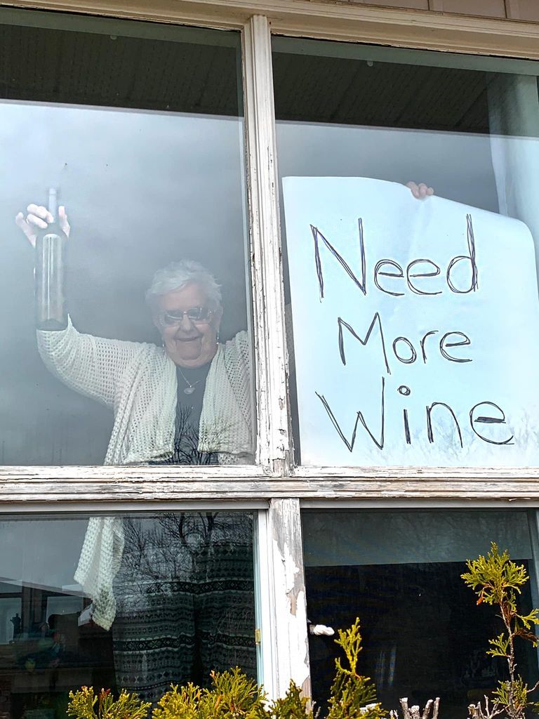 A Woman Went Viral For Holding Up A “Need More Wine” Sign