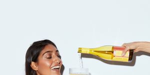 hand pouring wine for smiling woman