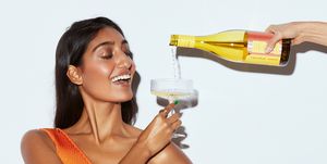 hand pouring wine for smiling woman