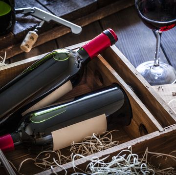 Wine bottles packed in a wooden box shot rustic wooden table