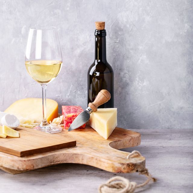 Wine With Cheese On Table Against Wall