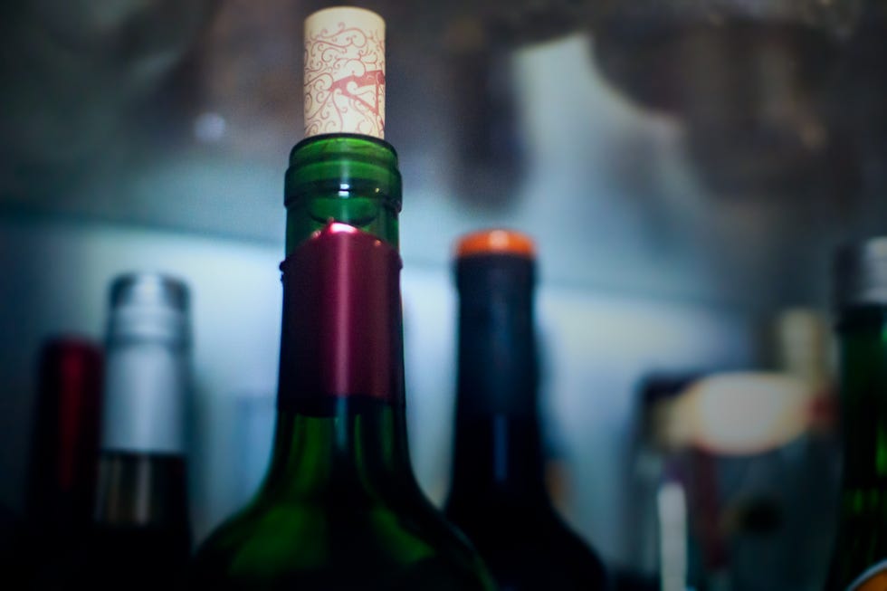 one open wine bottle in a dark fridge