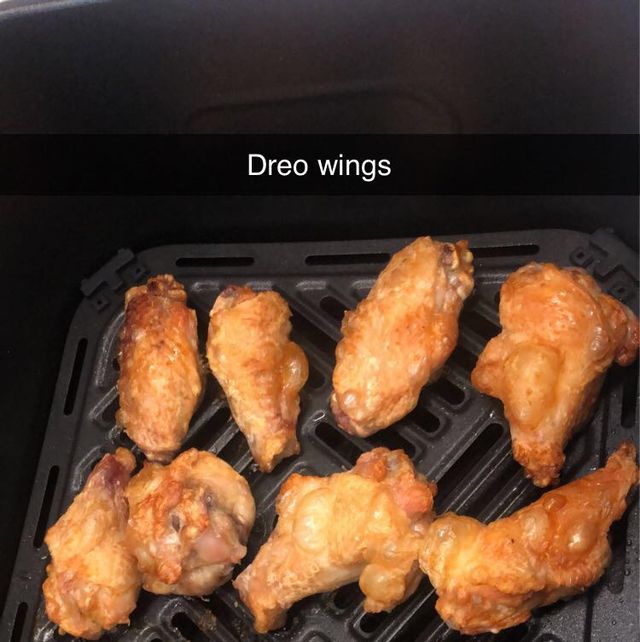 browned and crispy looking chicken wings in an air fryer basket