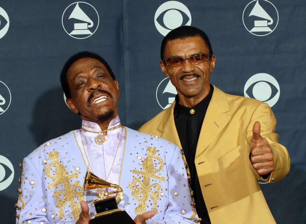 ike turner holding a trophy and smiling with son ike turner jr giving a thumbs up gesture next to him