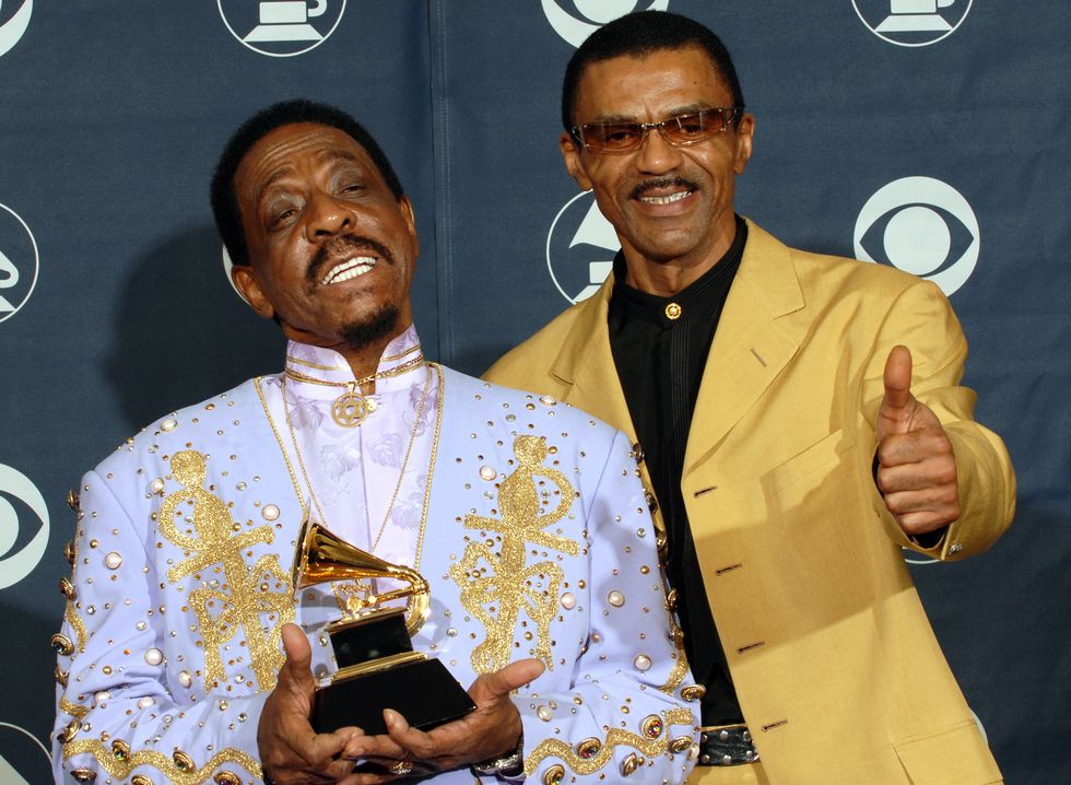 ike turner holding a trophy and smiling with son ike turner jr giving a thumbs up gesture next to him