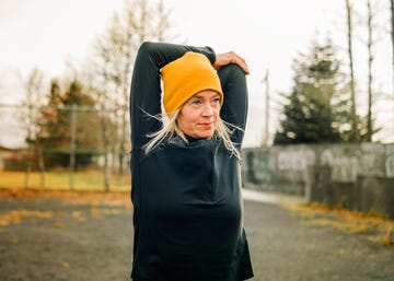 een vrouw doet een warming up in de winter voor het hardlopen