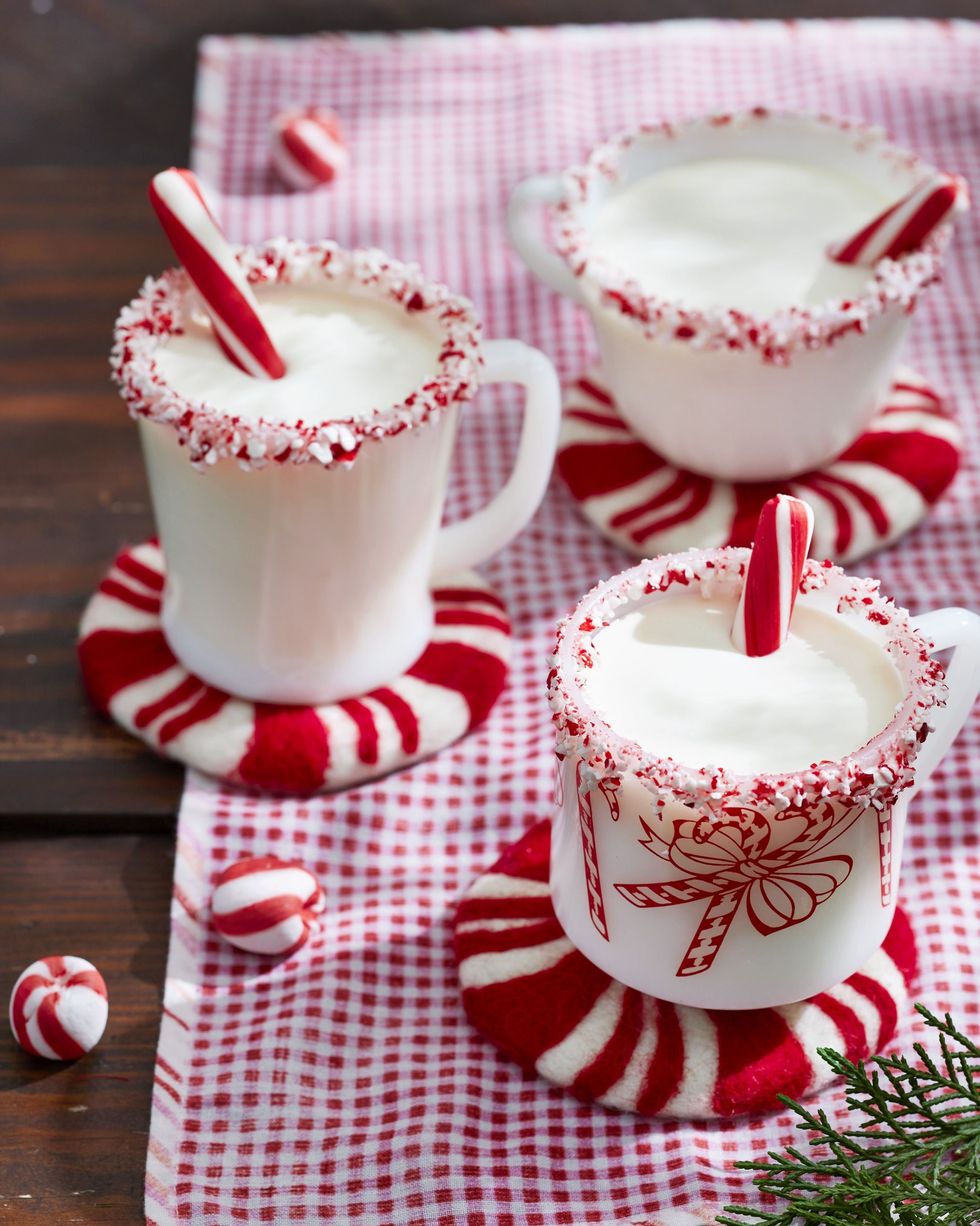 peppermint eggnog in white mugs with crushed candy cane on the rim