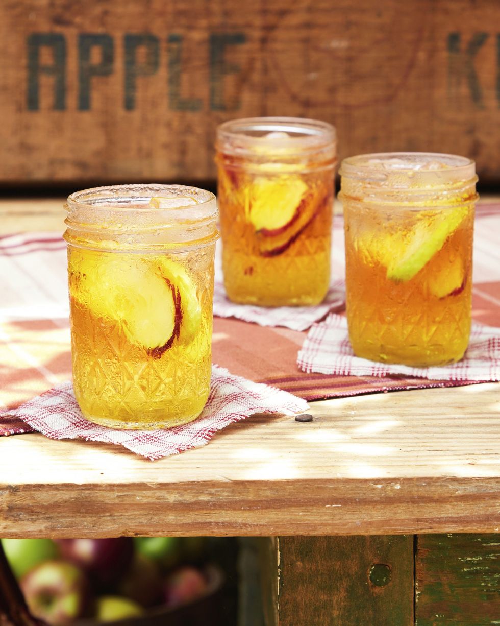 sparkling cider and bourbon cocktail in mason jars with slices of fresh apple