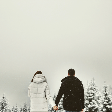 couple holding hands outside in the snow