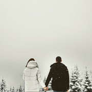 couple holding hands outside in the snow