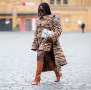 berlin, germany   january 19 lois opoku is seen wearing dress and coat with animal print baum und pferdgarten, asos boots in brown, white proenza schouler bag, burberry sunglasses during the mercedes benz fashion week berlin january 2021 on january 19, 2021 in berlin, germany photo by christian vieriggetty images