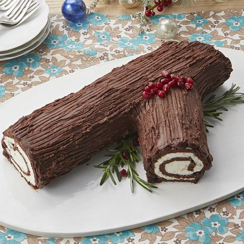 yule log on white platter with greens