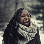 winter quotes young woman laughing while it's snowing outside