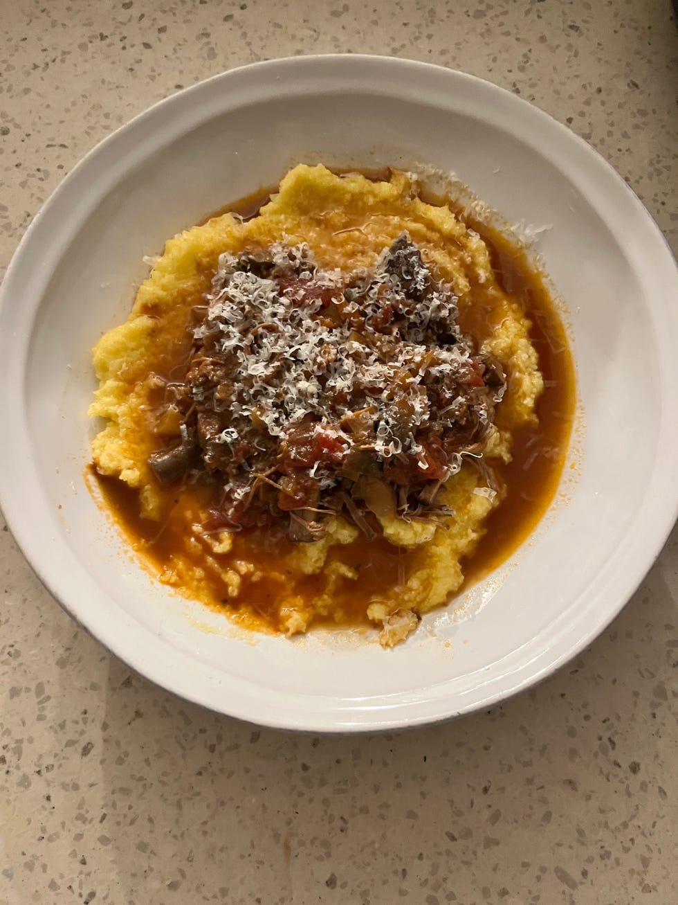 bowl of polenta topped with beef ragu