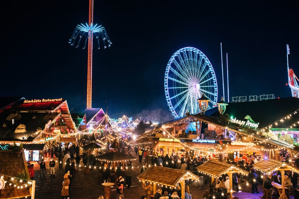 A lively night market filled with lights food stalls and amusement rides