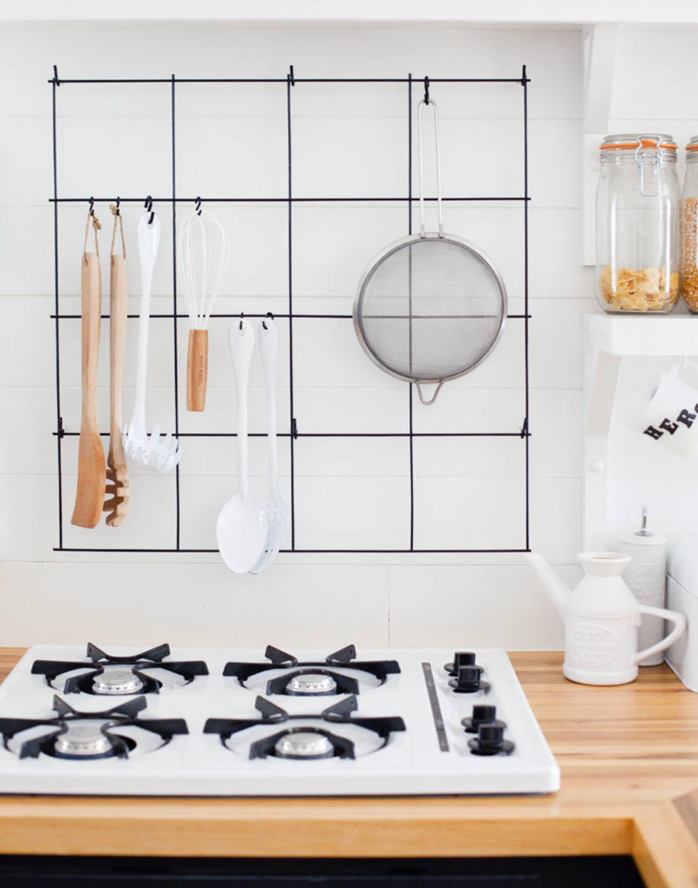 wallmounted utensil rack with kitchen tools and a gas stove