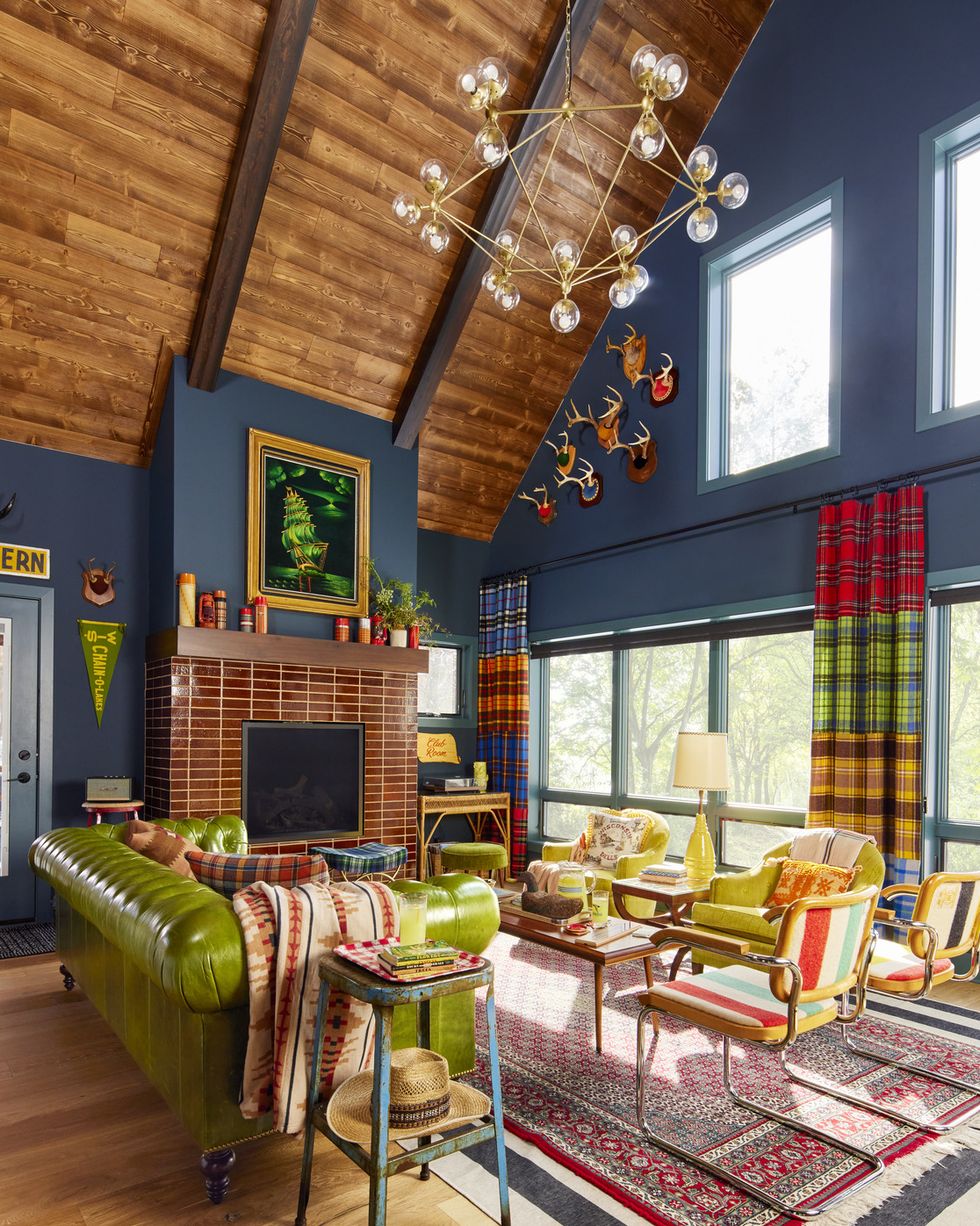 a living room with navy blue walls and green and red and yellow furniture and accessories