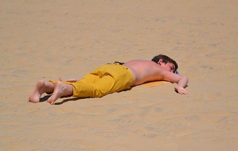man laying out without sunscreen
