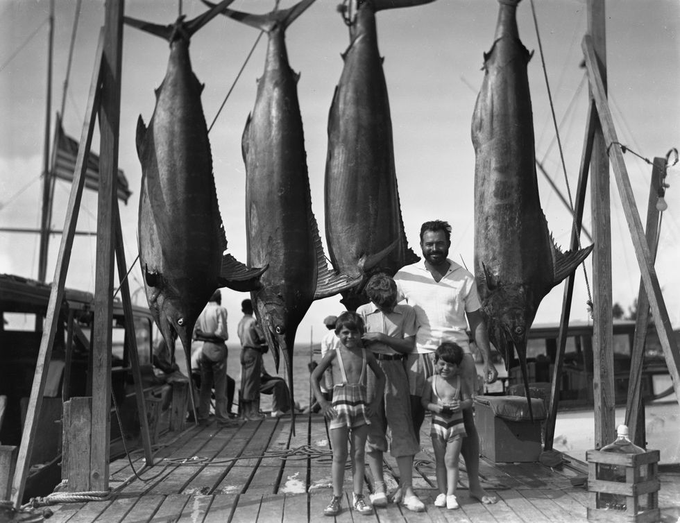 eh1697n          1935ernest hemingway stands with sons on the docks at bimini, bahamas l r patrick hemingway, john "bumby" hemingway, ernest hemingway, and gregory hemingwaykey west years, 1928 1937 box 10 folder 1please credit "photographer unknown papers of ernest hemingway photograph collection john f kennedy presidential library and museum, boston"