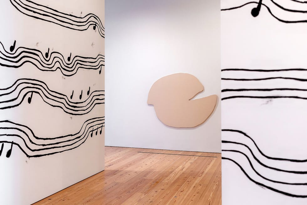 gallery interior featuring musical note patterns on walls and an abstract beige shape