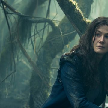 rosamund pike sitting in forest in wheel of time