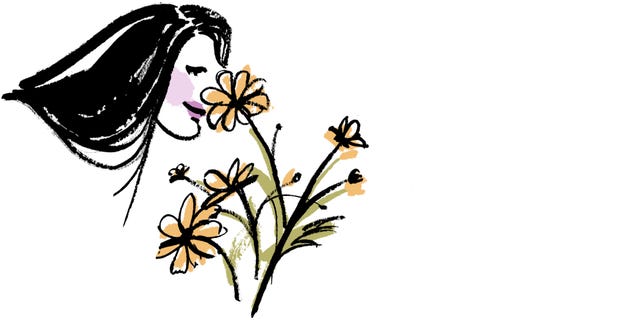 a woman with long hair leans towards a bouquet of flowers