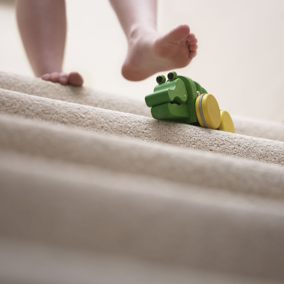 woman about to slip on toy left on staircase