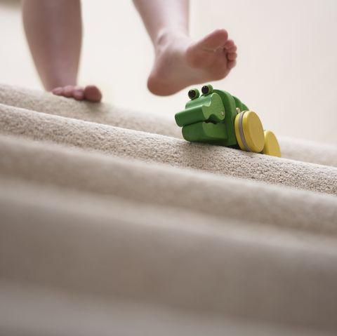 Woman about to slip on toy left on staircase