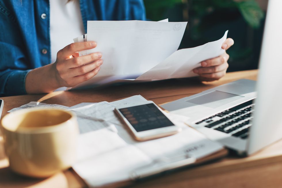 woman accountant use calculator and computer with holding pen on