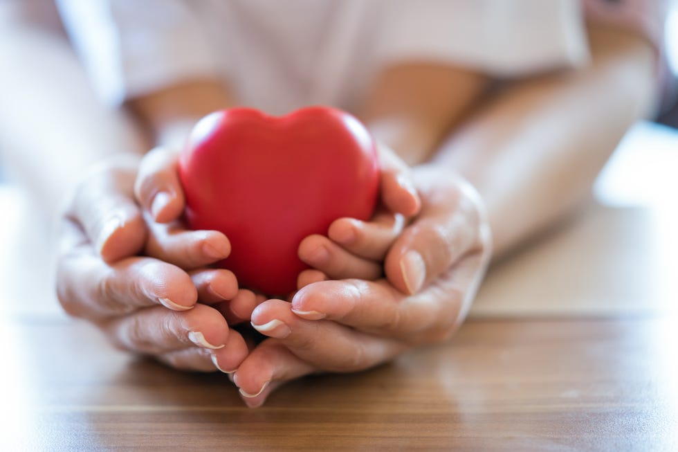 woman and child holding red heart