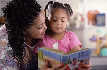 a mom reading to her little girl the bible