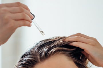 woman applies oil to her hair with pipette beauty caring for scalp and hair