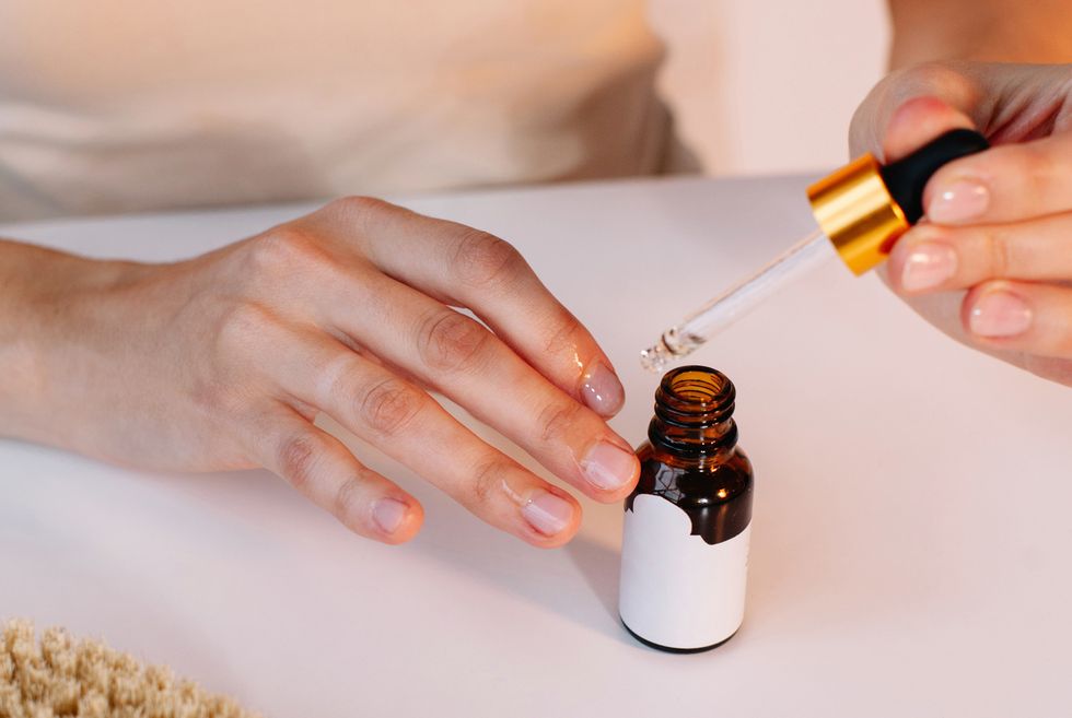 woman applying cuticle oil to her nails